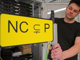 SpaceNet Award Mann vor einem Serverschrank mit einem Schild wo NC P drauf steht